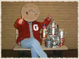 Mascot of Pennies for the Bot, Mr. Penny, with school collection cans